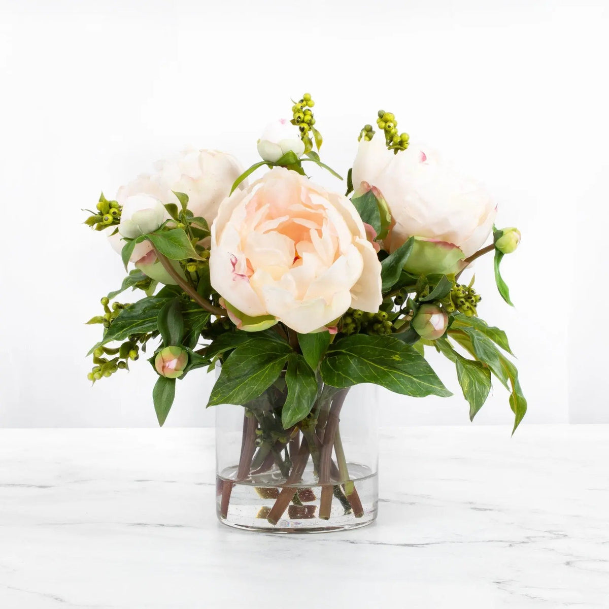 Blush peony trio with buds and foliage in a clear glass vase, 10 inches high