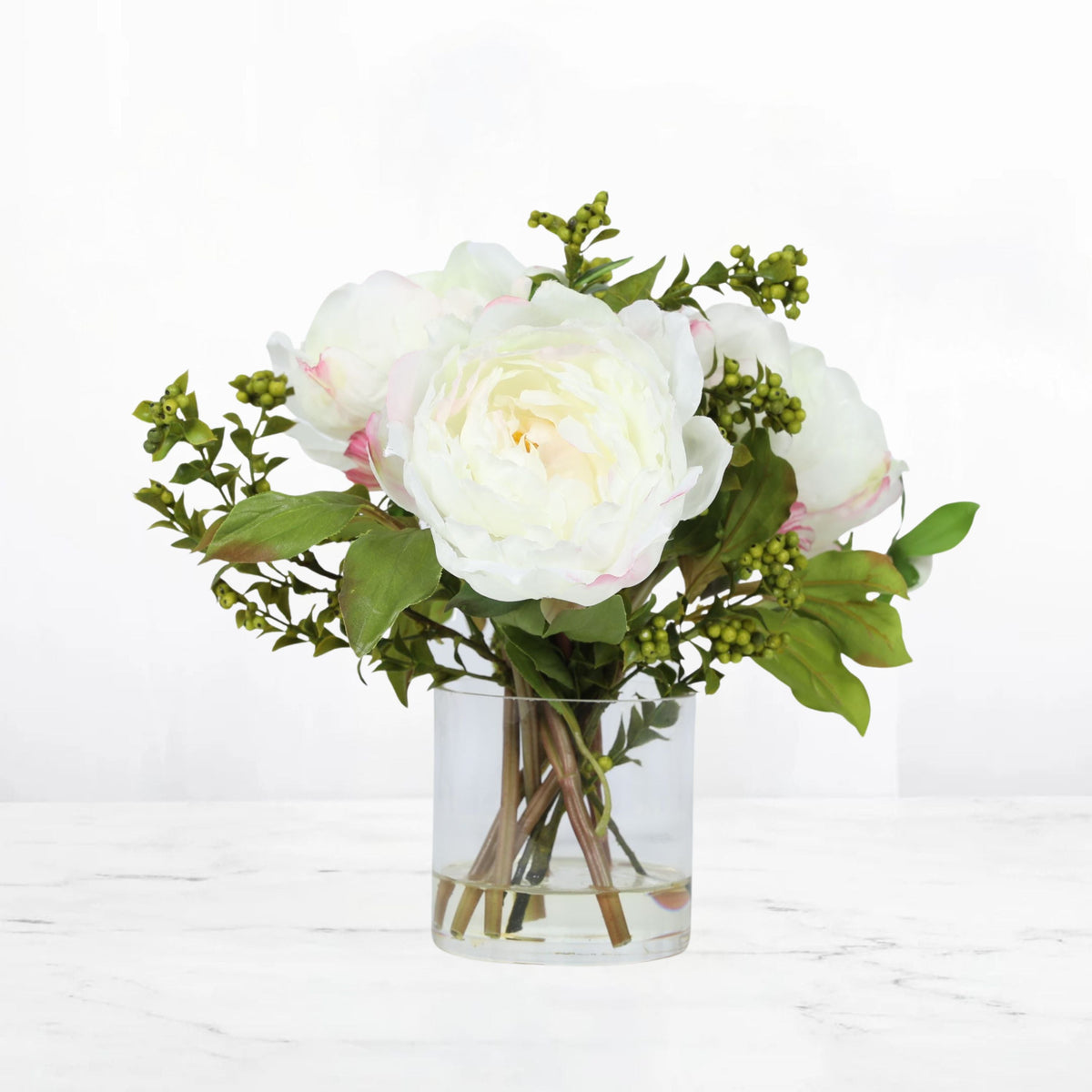 White peony arrangement with pale pink edges in a clear glass vase, 10 inches high